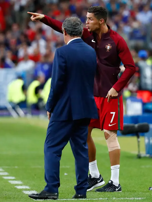 Ronaldo berdiskusi dengan Fernando Santos saat menjadi asisten pelatih dadakan saat laga final Euro 2016 di Stade de France, Saint-Denis, Paris, Prancis, (10/7). Ronaldo sempat bermain selama 30 menit pada Final tersebut. (REUTERS/Kai Pfaffenbach)