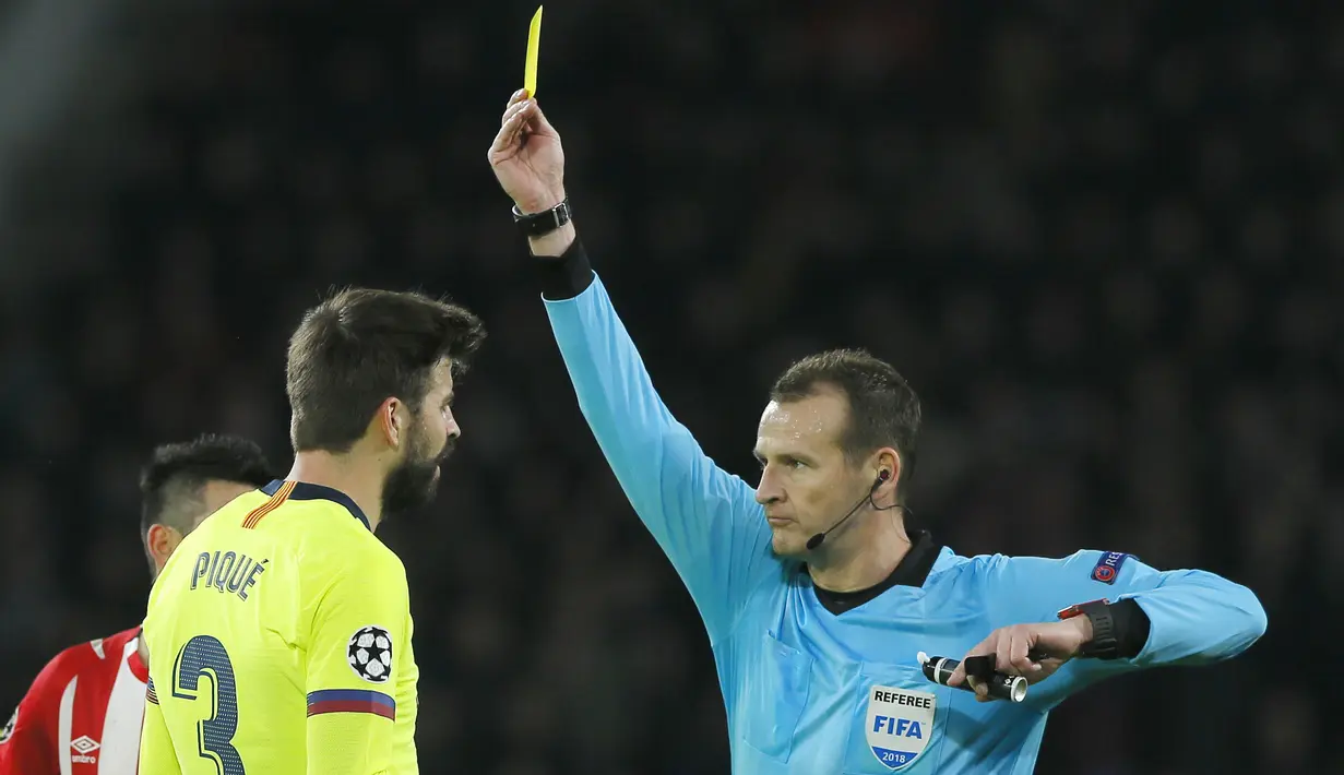 Bek Barcelona, Gerard Pique, mendapat kartu kuning saat melawan PSV Eindhoven pada laga Liga Champions di Stadion Philips, Rabu (28/11). Barcelona menang 2-1 atas PSV Eindhoven. (AP/Peter Dejong)