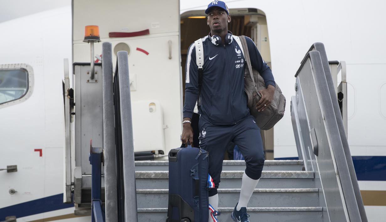 Gaya Paul Pogba menenteng koper saat tiba di Sheremetyevo international airport, Moskow, Rusia, (10/6/2018). Pada laga perdana Prancis akan melawan Australia. (AP/Pavel Golovkin)