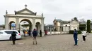Kerabat seorang warga yang sudah meninggal menjaga jarak aman saat berkumpul dalam upacara pemakaman selama masa lockdown untuk menghentikan penyebaran pandemi virus corona COVID-19 di luar kuburan kecil Bolgare, Lombardy, Italia, Senin (23/3/2020). (Piero CRUCIATTI / AFP)