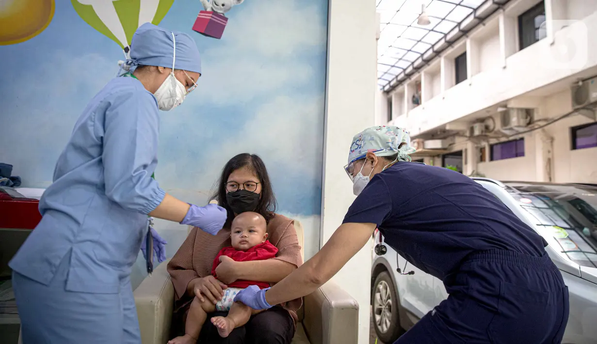 Petugas memeriksa kesehatan serta imunisasi pasien anak di RSIA Bunda, Jakarta, Jumat (18/3/2022). Pemeriksaan dilakukan drive thru guna memberi rasa aman orangtua, khususnya ibu yang ingin melaksanakan imunisasi serta pemeriksaan nonpenyakit di tengah pandemi COVID-19. (Liputan6.com/Faizal Fanani)