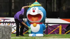Seorang staf membersihkan dan mendisinfeksi patung Doraemon di pameran "Doraemon's Time-Travelling Adventures in Singapore" yang digelar di Museum Nasional Singapura pada 3 November 2020. Pameran ini akan berlangsung hingga 27 Desember 2020. (Xinhua/Then Chih Wey)
