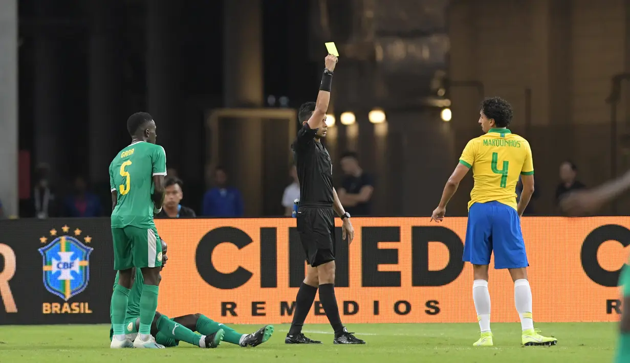 Bek Brasil, Marquinhos mendapat kartu kuning dari wasit saat bertanding melawan Senegal pada pertandingan persahabatan di Stadion Nasional di Singapura (10/10/2019). Brasil bermain imbang dengan Senegal 1-1. (AFP Photo/Roslan Rahman)