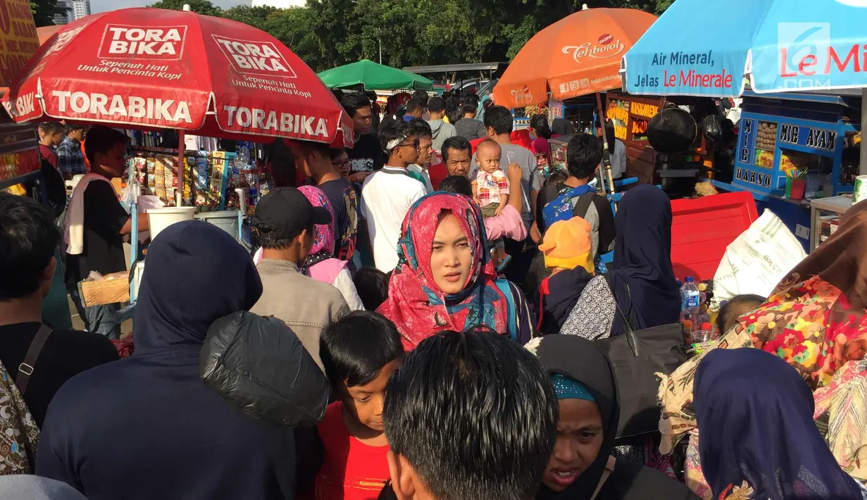 PKL memenuhi akses jalan di sekitar kawasan Monas, Jakarta, Senin (1/1). Kurangnya pengawasan menyebabkan banyak PKL dan parkir liar memenuhi kawasan tersebut sehingga menimbulkan kesemrawutan. (Liputan6.com/Immanuel Antonius)