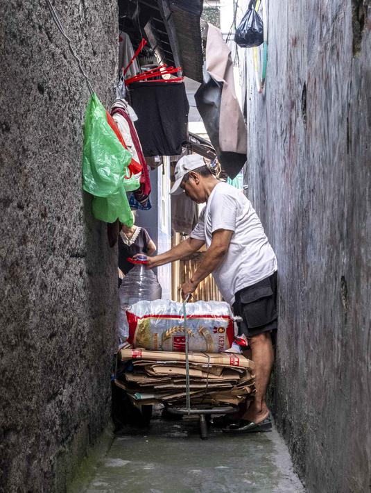 Seorang pria menyiapkan sampah anorganik rumah tangga (dalam bentuk karton dan botol plastik) untuk disimpan di bank sampah setempat, Jakarta, Kamis 4 Juni 2026, sebagai bagian dari instruksi Pemprov DKI yang mewajibkan warga memilih dan memilah sampah untuk mengurangi beban sampah yang semakin menumpuk di ibu kota. (BAY ISMOYO/AFP)