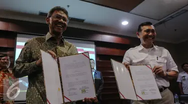 Luhut Binsar Pandjaitan (kanan) dan Ardan Adi Perdana  memperlihatkan MoU di Gedung Bina Graha, Jakarta, Jumat (10/7/2015).  MoU ini akan menjadi landasan pengawasan serta pengendalian 100 program prioritas Presiden Jokowi. (Liputan6.com/Faizal Fanani)