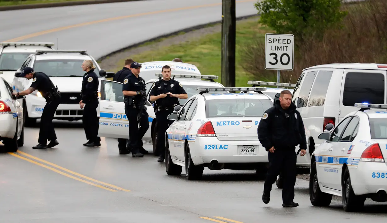 Petugas kepolisian menyisir area hutan untuk mencari tersangka penembakan di sebuah restoran Waffle House dekat Nashville, Tennessee, Minggu (23/4). Polisi mengatakan pelaku melepaskan jaketnya dan kabur dengan berjalan kaki. (AP Photo/Mark Humphrey)