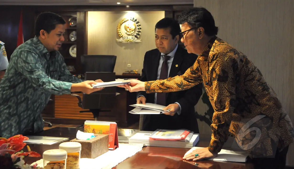  MendagrI Tjahjo Kumolo (kanan) memberikan berkas kepada Wakil Ketua DPR Fahri Hamzah (kiri), disaksikan Ketua DPR Setya Novanto (tengah) di Gedung Nusantara lll, Komplek Parlemen Senayan, Jakarta, Senin (11/5/2015). (Liputan6.com/Andrian M Tunay)