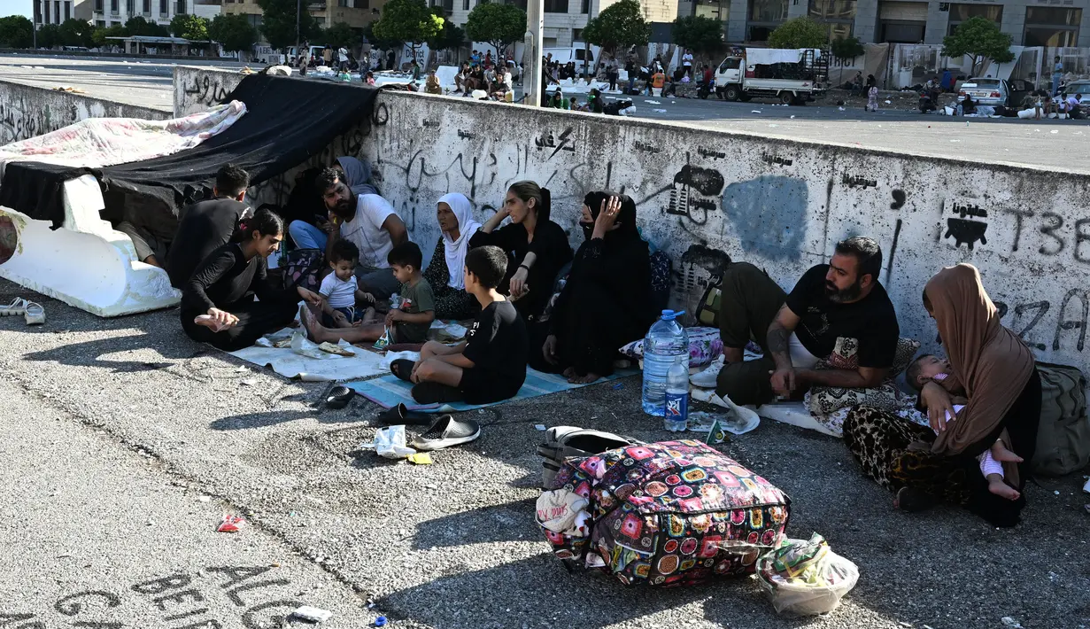 Puluhan warga berikut anak-anak dan perempuan panik melarikan diri dari serangan besar-besaran Israel. (JOSEPH EID/AFP)