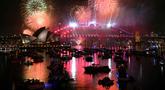 Cahaya kembang api menerangi langit di atas Jembatan Pelabuhan Sydney dan Gedung Opera Sydney, Australia, selama perayaan malam pergantian tahun, pada 1 Januari 2026. (Saeed KHAN/AFP)