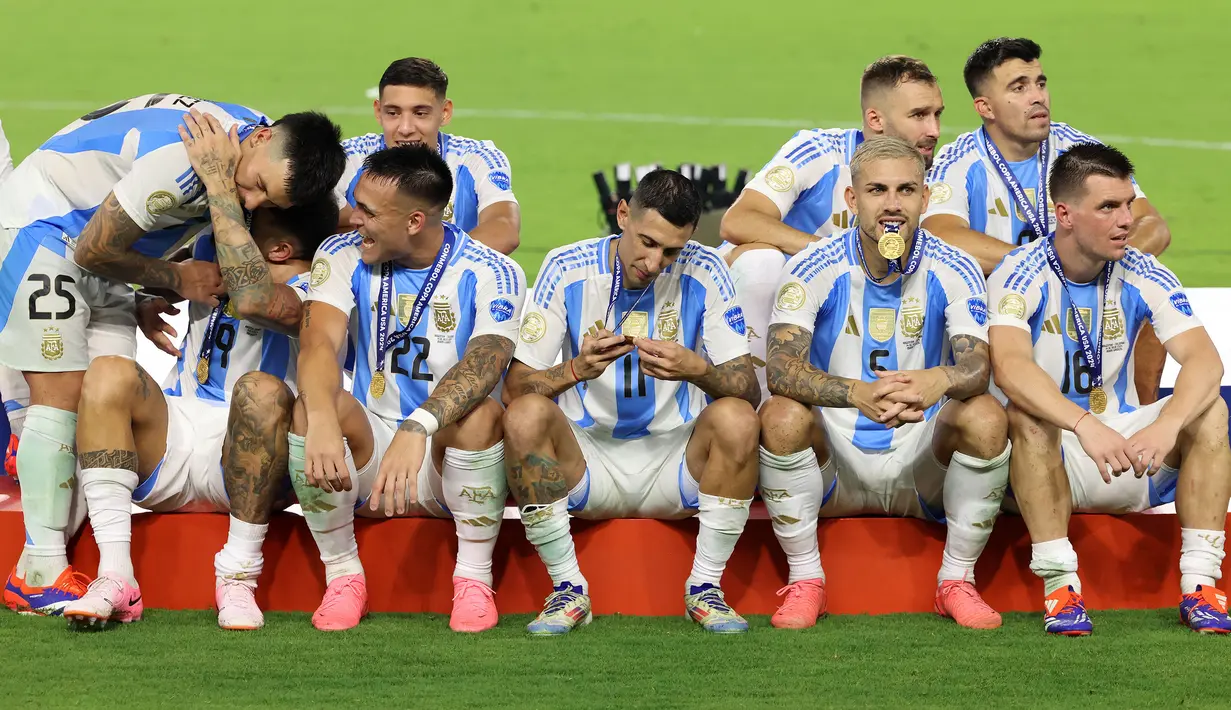 Pemain Argentina, Angel Di Maria (tengah) melihat medalinya setelah memenangkan Copa America 2024 di Hard Rock Stadium, Miami, Florida, Senin (15/07/2024) WIB. (AFP/Buda Mendes)