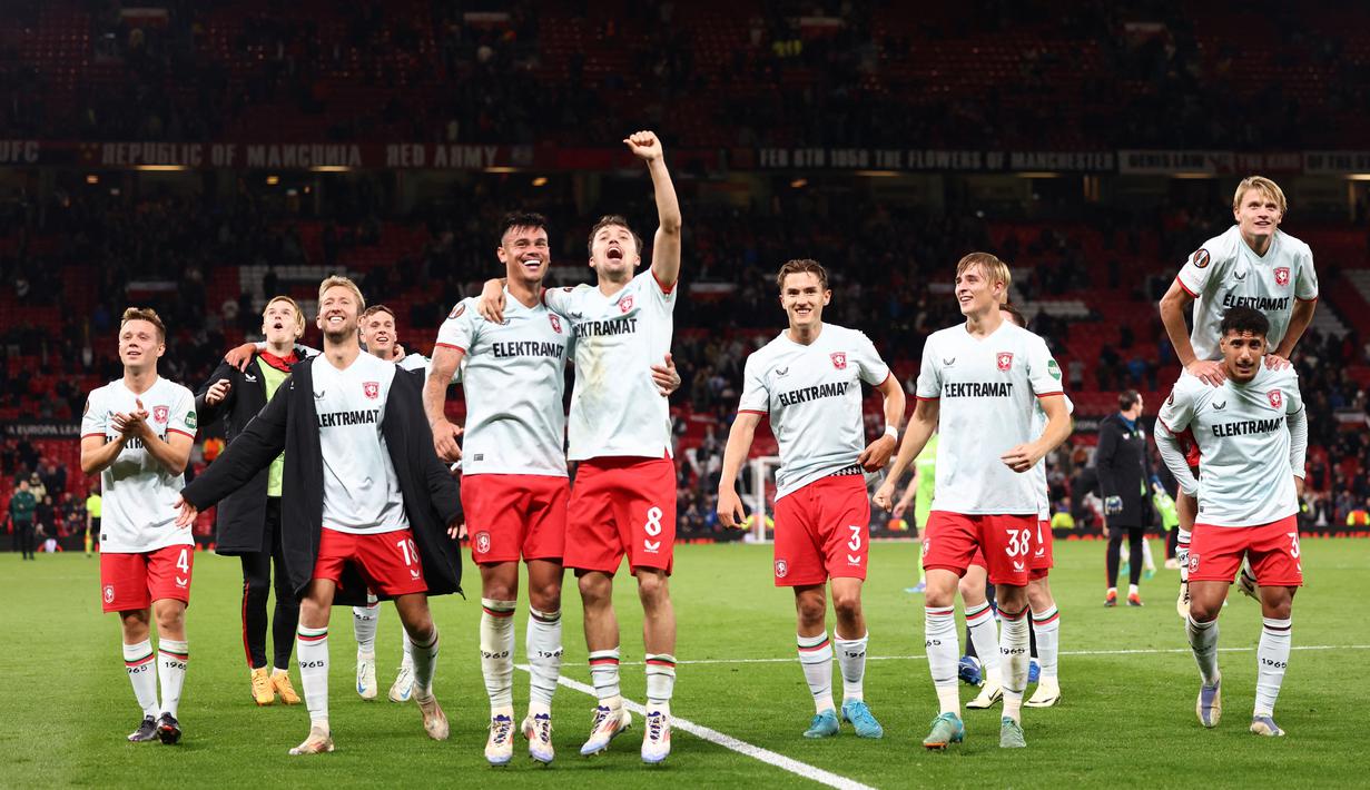 Para pemain FC Twente merayakan hasil imbang melawan Manchester United pada matchday 1 Liga Europa 2024/2025 di Old Trafford, Kamis (26/9/2024) dini hari WIB. (AP Photo/Dave Thompson)