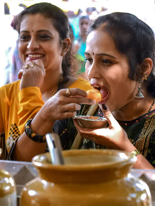 Pengunjung mencoba makanan dalam festival Bengaluru Aaharotsava, Bangalore, India, Jumat (18/10/2019). Lebih dari 1.000 hidangan hadir dalam Bengaluru Aaharotsava. (Manjunath Kiran/AFP)