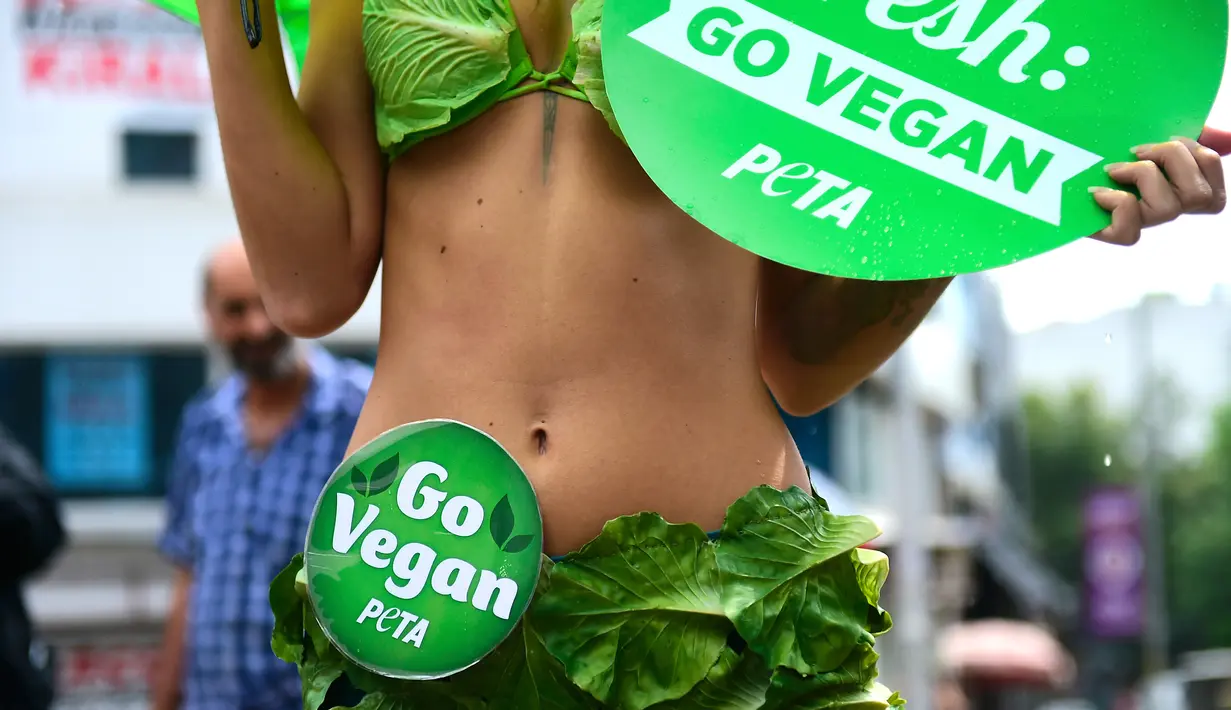 Salah satu "Lettuce Ladies" aktivis PETA berdiri dalam sebuah acara yang mempromosikan gaya hidup vegan di Istanbul, Turki (17/8). Mereka mengajak masyarakat untuk beralih dengan gaya hidup vegetarian yang sehat. (AFP Photo/Yasin Akgul)