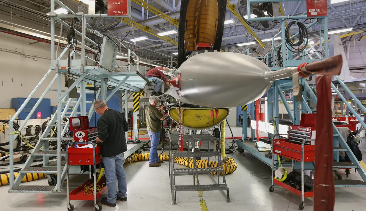 Mekanik pesawat terbang memperbaiki pesawat F-16 Falcon di pangkalan Angkatan Udara Hill di Ogden, Utah (20/12). Pangkalan Angkatan Udara Hill ini merupakan bengkel pesawat jet tempur terbesar di Amerika Serikat. (George Frey/Getty Images/AFP)