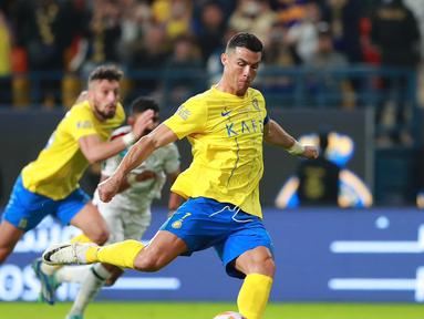 Pemain Al Nassr, Cristiano Ronaldo, menendang bola dari titik penalti yang membuahkan gol ke gawang Al Ettifaq dalam pertandingan lanjutan Saudi Pro League 2023/2024 yang berlangsung di Al Awwal Park, Jumat (22/12/2023). (X/Al Nassr FC)