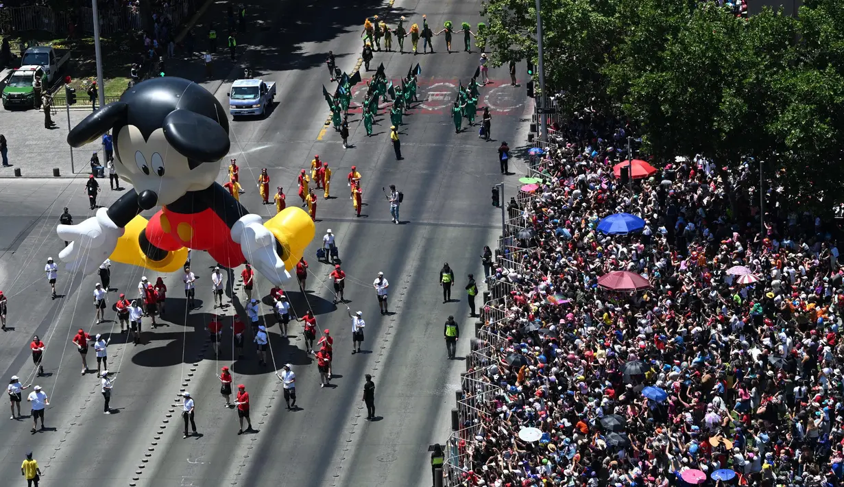 Di sepanjang jalan, warga antusias meyambut meriah parade beragam balon karakter kartun fiksi dan film animasi. (RODRIGO ARANGUA/AFP)