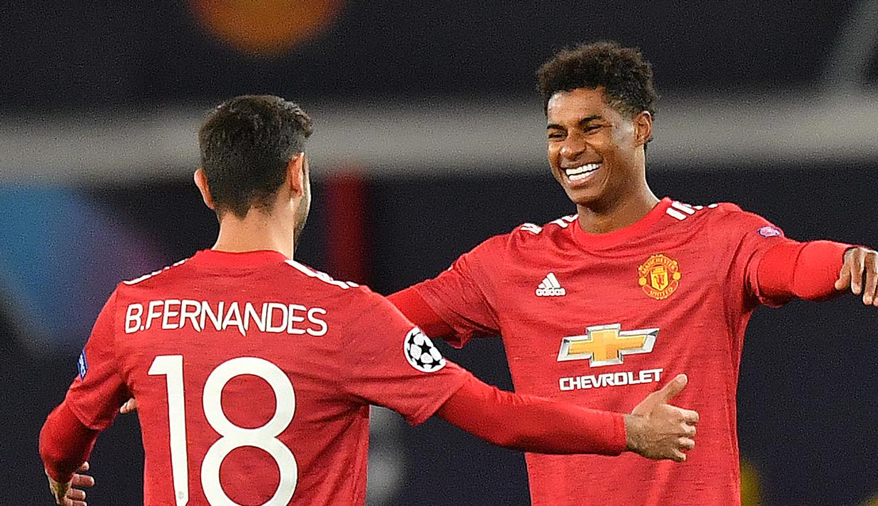Striker Manchester United, Marcus Rahford merayakan gol bersama Bruno Fernandes dalam lanjutan Liga Champions 2020/2021 di grup H saat menghadapi RB Leipzig di Stadion Old Trafford, Kamis (29/10/2020) dini hari WIB. Manchester United menang 5-0 atas RB Leipzig. (AFP/Anthony Devlin).