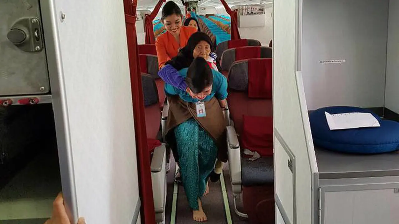 Foto pramugari Garuda Indonesia menggendong seorang nenek keluar pesawat menjadi viral.