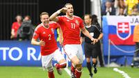 Selebrasi bintang Wales, Gareth Bale (kanan) usai mencetak gol ke gawang Slovakia pada pertandingan Grup B Piala Eropa 2016, di Stade de Bordeaux, Sabtu (11/6/2016). (AFP/Joe Klamar). 