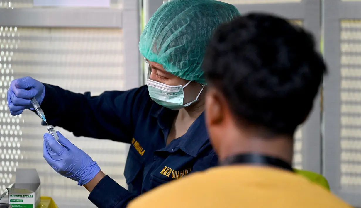 Petugas kesehatan menyiapkan suntikan vaksinasi COVID-19 keempat atau booster kedua untuk petugas bandara di kantor otoritas Bandara Ngurah Rai, dekat Denpasar, Bali, Senin (30/1/2023). Pemerintah Provinsi (Pemprov) Bali melakukan program vaksinasi booster kedua usai dibukanya penerbangan langsung (direct flight) dari China pada Minggu (22/1) lalu. (SONNY TUMBELAKA / AFP)