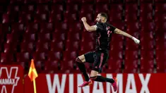 Pemain Real Madrid Karim Benzema melakukan selebrasi usai mencetak gol ke gawang Granada pada pertandingan La Liga di Stadion Los Carmenes, Granada, Spanyol, Kamis (13/5/2021). Real Madrid menang telak 4-1 atas Granada. (AP Photo/Fermin Rodriguez)