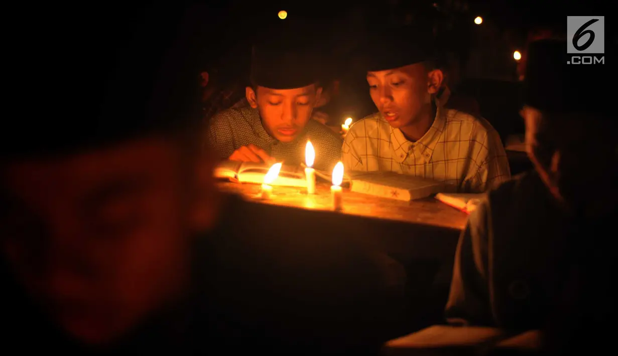 Santri dari Pondok Pesantren  Nurul Hidayah melakukan tadarus alquran dengan penerangan obor di tengah sawah Dusun Tempel, Desa Sempu, Kecamatan Andong, Kabupaten Boyolali, Selasa ( 21/5/2019). Pengajian tersebut untuk menyambut malam Nuzulul Quran pada 17 Ramadan 1440 Hijriah. (Liputan6.com/Gholib)