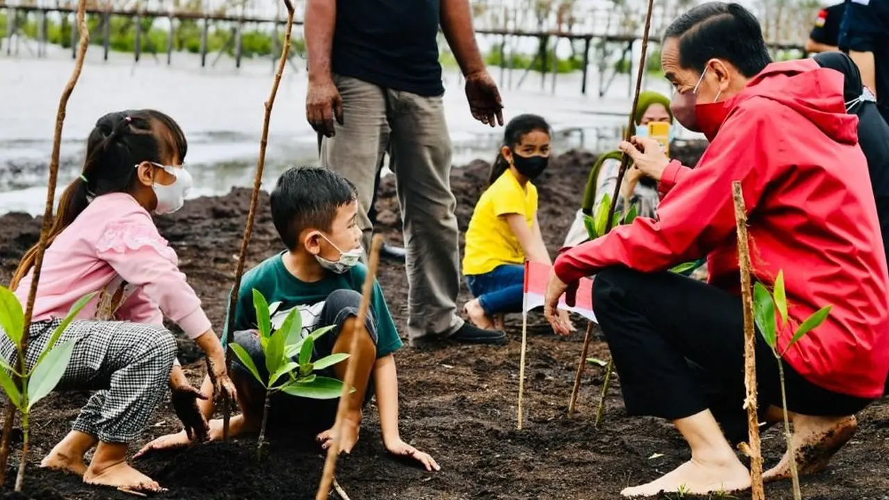 Presiden Jokowi menanam pohon mangrove bersama masyarakat di Pantai Wisata Raja Kecik Kabupaten Bengkalis, Riau, Selasa (28/9/2021).