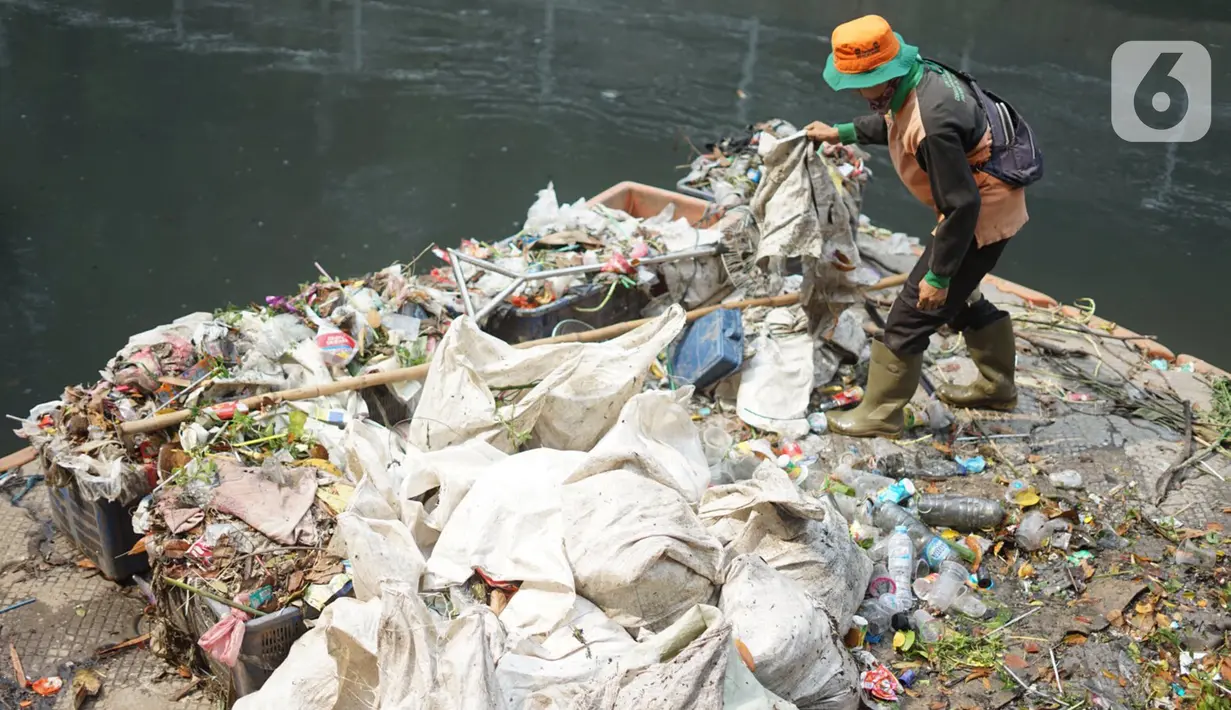Petugas membersihkan sampah di sepanjang Kali Taman Anggrek, Jakarta, Rabu (8/7/2020). Banyaknya limbah menyebabkan Kali Taman Anggrek menjadi berwarna hitam dan berbau tidak sedap meskipun dibersihkan setiap hari. (Liputan6.com/Immanuel Antonius)