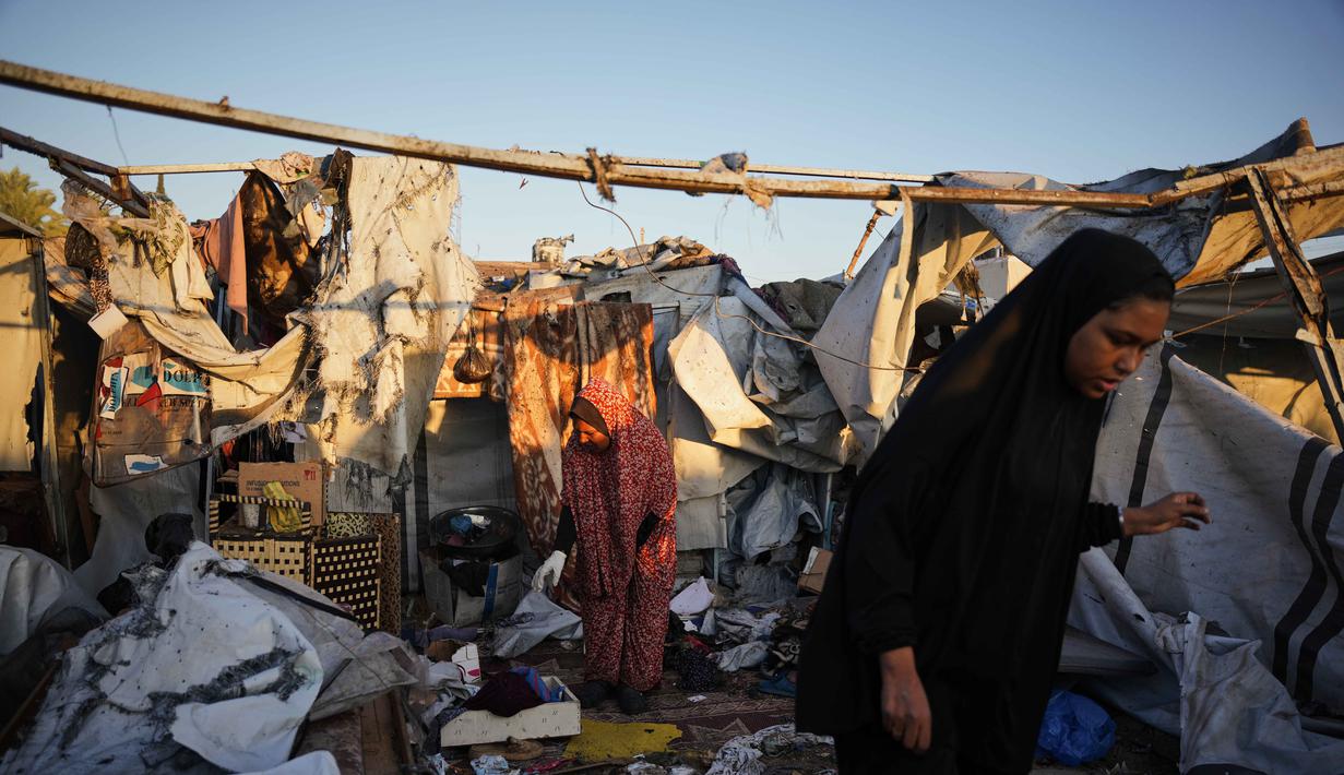 Warga Palestina yang mengungsi memeriksa kerusakan akibat serangan tentara Israel di kamp tenda mereka di Deir al-Balah, Jalur Gaza, Rabu 29 Oktober 2025. Serangan tersebut menyebabkan beberapa warga Palestina tewas, termasuk rusaknya sejumlah tenda pengungsian. (AP Photo/Abdel Kareem Hana)