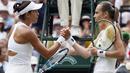 Garbine Muguruza (kiri) bersalaman dengan Magdalena Rybarikova usai laga semifinal tunggal putri Wimbledon 2017 di London; (13/7/2017). Muguruza menang 6-1, 6-1. (AP/Kirsty Wigglesworth)