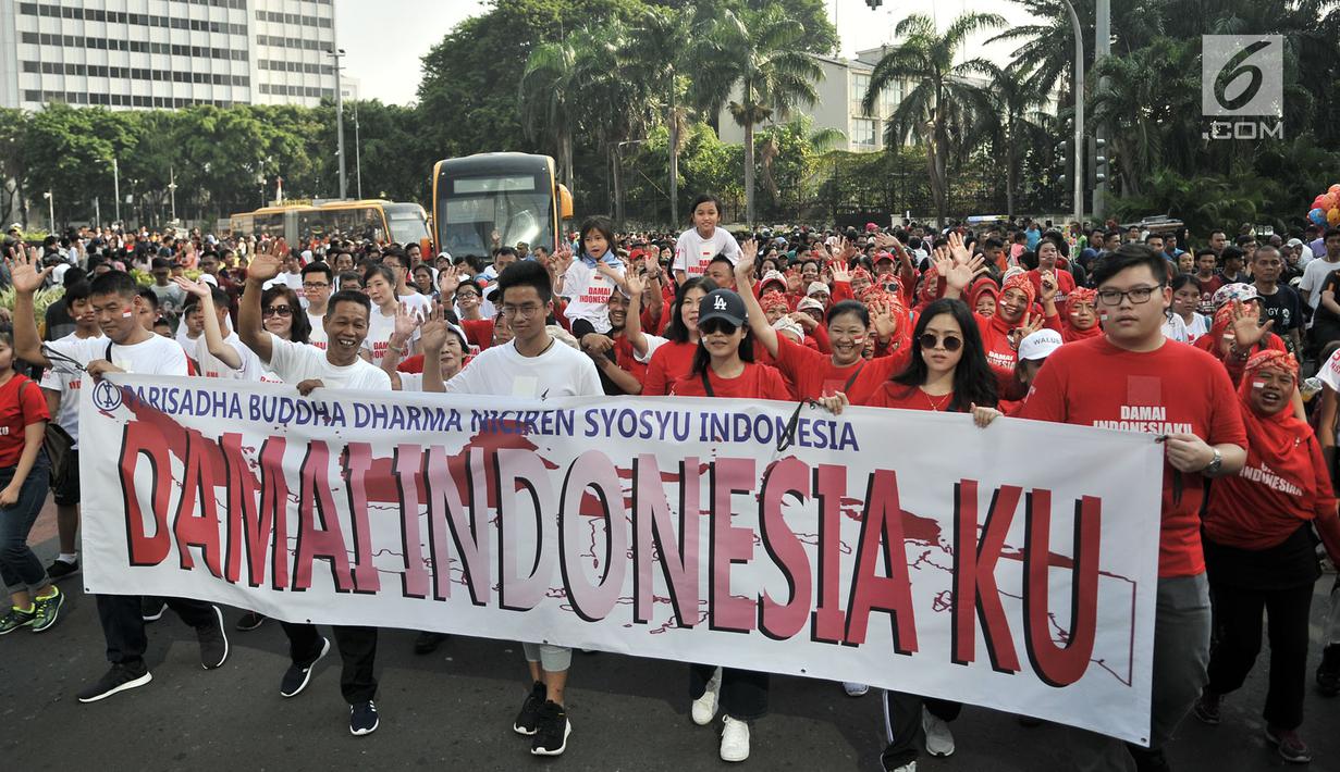 Umat lintas agama membentangkan spanduk saat Gerak Jalan Kerukunan Umat Beragama di kawasan Car Free Day, Jakarta, Minggu (21/10). Dalam kesempatan itu, perwakilan lintas agama juga mendeklarasikan pelaksanaan pemilu damai. (Merdeka.com/ Iqbal S. Nugroho)