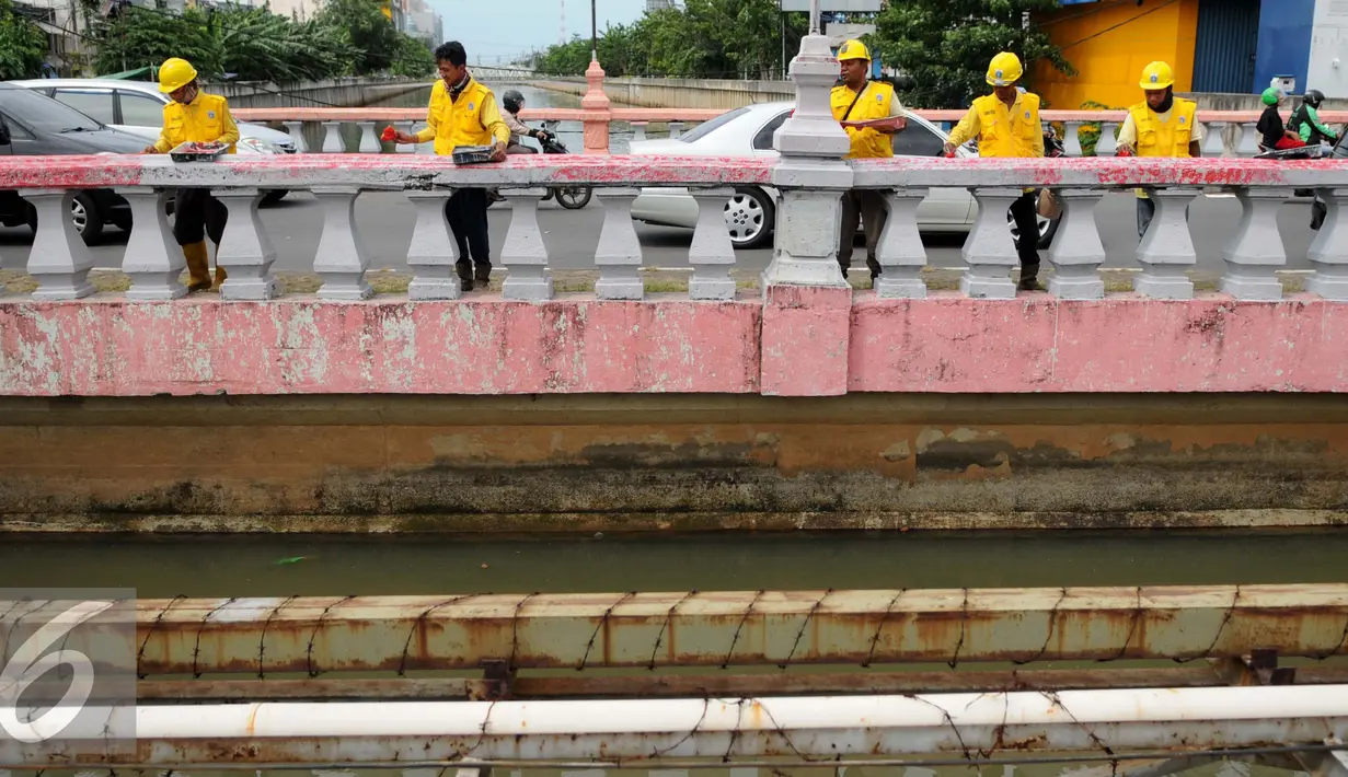 Sejumlah pekerja melakukan pengecatan Jembatan Merah di Jalan Pangeran Jayakarta, Jakarta, Selasa (27/12). Pengecatan dilakukan untuk memperindah jembatan agar terlihat bersih dan terawat. (Liputan6.com/Gempur M. Surya)