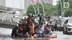 Pengendara sepeda motor menggunakan jasa rakit saat banjir melanda Cempaka Putih, Jakarta, Minggu (23/2/2020). Pengendara memanfaatkan jasa angkutan rakit yang ditawarkan warga agar dapat melewati banjir. (merdeka.com/Iqbal S. Nugroho)