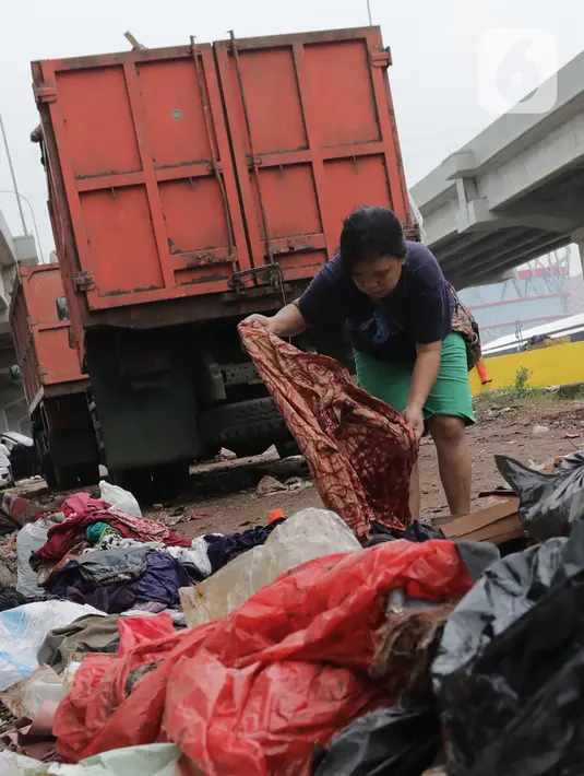 Warga memilah sampah sisa banjir yang menumpuk di kawasan Cipinang Melayu, Jakarta, Rabu (8/1/2020). Banjir yang melanda Jakarta dan sekitarnya sejak 1 Januari 2020 lalu menyisakan tumpukan sampah di sejumlah titik. (Liputan6.com/Herman Zakharia)