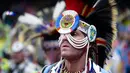 Seorang pria mengenakan kostum dan atribut kepala bersiap mengikuti Grand Entry of the Denver March Powwow di Denver, Colorado (24/3). (AFP/Jason Connolly)