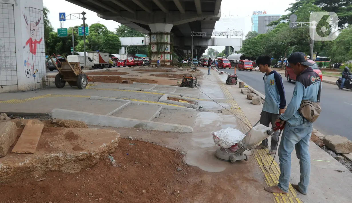 Pekerja menyelesaikan pembangunan Skate Park kolong Flyover Pasar Rebo, Jakarta, Selasa (10/12/2019). Adapun anggaran untuk pembuatan skatepark tersebut sebesar Rp14,3 miliar. (Liputan6.com/Herman Zakharia)