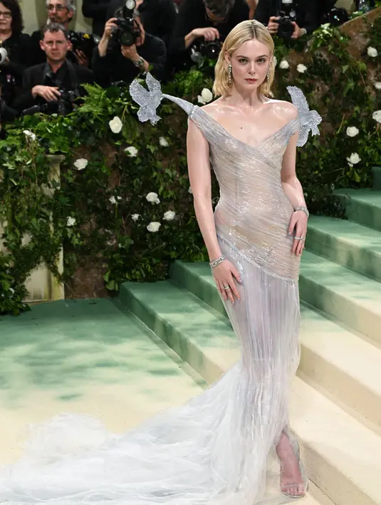 Elle Fanning tampil bak peri dalam balutan gaun Balmain khusus miliknya yang menampilkan bodysuit warna nude-nya dan patung burung seperti es yang duduk di bahunya. [@fashionchick]
