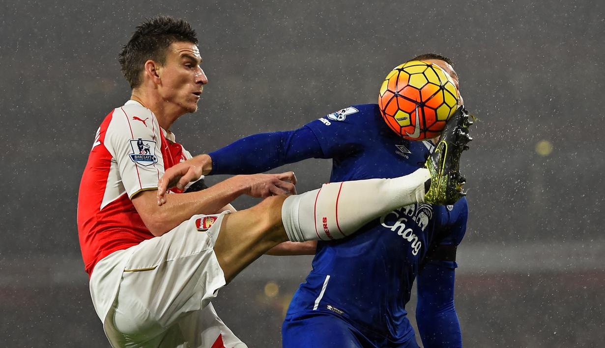 Pemain Arsenal, Laurent Koscielny, berebut bola dengan pemain Everton dalam lanjutan Liga Premier Inggris di Stadion Emirates, London, Inggris. Sabtu (24/10/2015) malam WIB. (Reuters/ Dylan Martinez)