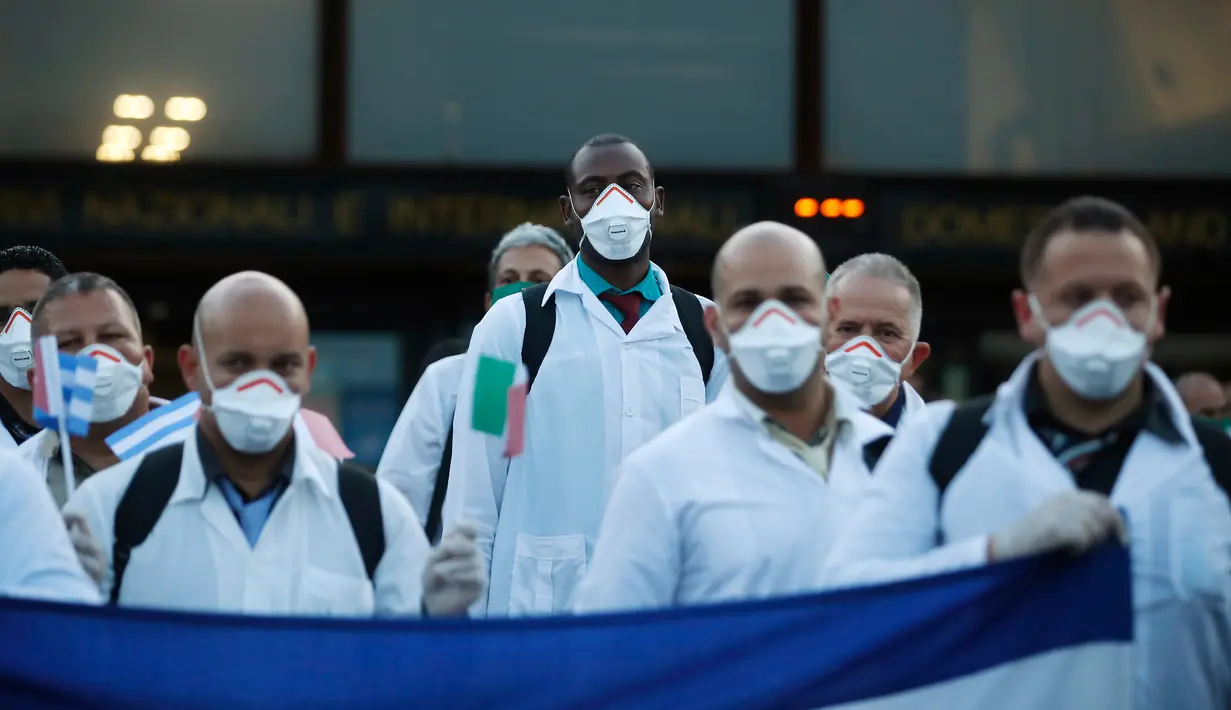 Petugas medis dan paramedis dari Kuba berpose setibanya di bandara Malpensa di Milan, Italia, Minggu (22/3/2020). Sebanyak 53 orang dokter dan perawat menjadi kontingen bantuan medis pertama Kuba untuk membantu mengendalikan pandemi virus Corona di kota kecil Crema, Lombardy. (AP/Antonio Calanni)