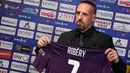 Rekrutan baru Fiorentina, Franck Ribery, menunjukan jersey saat sesi perkenalan di Stadion Artemio Franchi, Florence, Kamis (22/8). Gelandang asal Prancis ini didatangkan secara gratis dari Bayern Munchen. (AFP/Andreas Solaro)