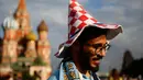 Seorang pria dari Palestina mengenakan topi yang menunjukkan dukungannya untuk tim Kroasia saat ia mengunjungi Lapangan Merah jelang final Piala Dunia 2018 antara Prancis melawan Kroasia di Moskow, Rusia, (13/7).  (AP Photo/Rebecca Blackwell)