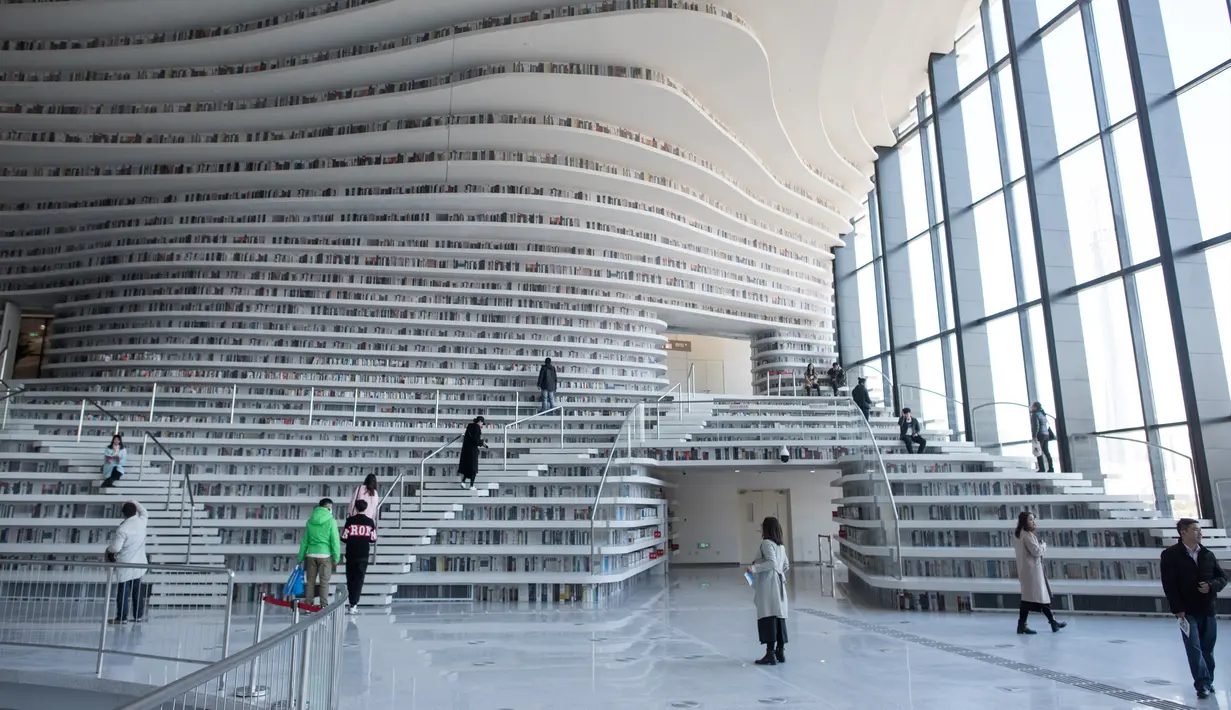 Sejumlah pengunjung melihat buku koleksi Perpustakaan Binhai Tianjin di China (14/11). Perpustakaan ini menempati area seluas 33.700 meter persegi dan dipenuhi oleh 1,2 juta buku yang sebagian besar tentang buku sains-fiksi. (AFP/Fred Dufour)