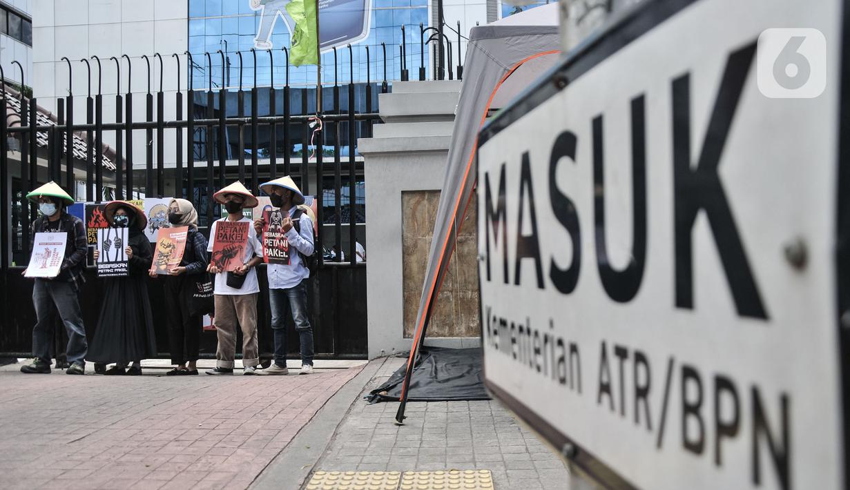 Aktivis Gerakan Rakyat untuk Kedaulatan Agraria membawa poster saat aksi mogok makan di depan Kantor Kementerian ATR/BPN, Jakarta, Senin (20/2/2023). Mereka juga menuntut Presiden Joko Widodo menyelesaikan kasus warga Pakel Banyuwangi dan memulihkan hak-hak ekonomi, sosial, budaya mereka yang terampas. (merdeka.com/Iqbal S Nugroho)