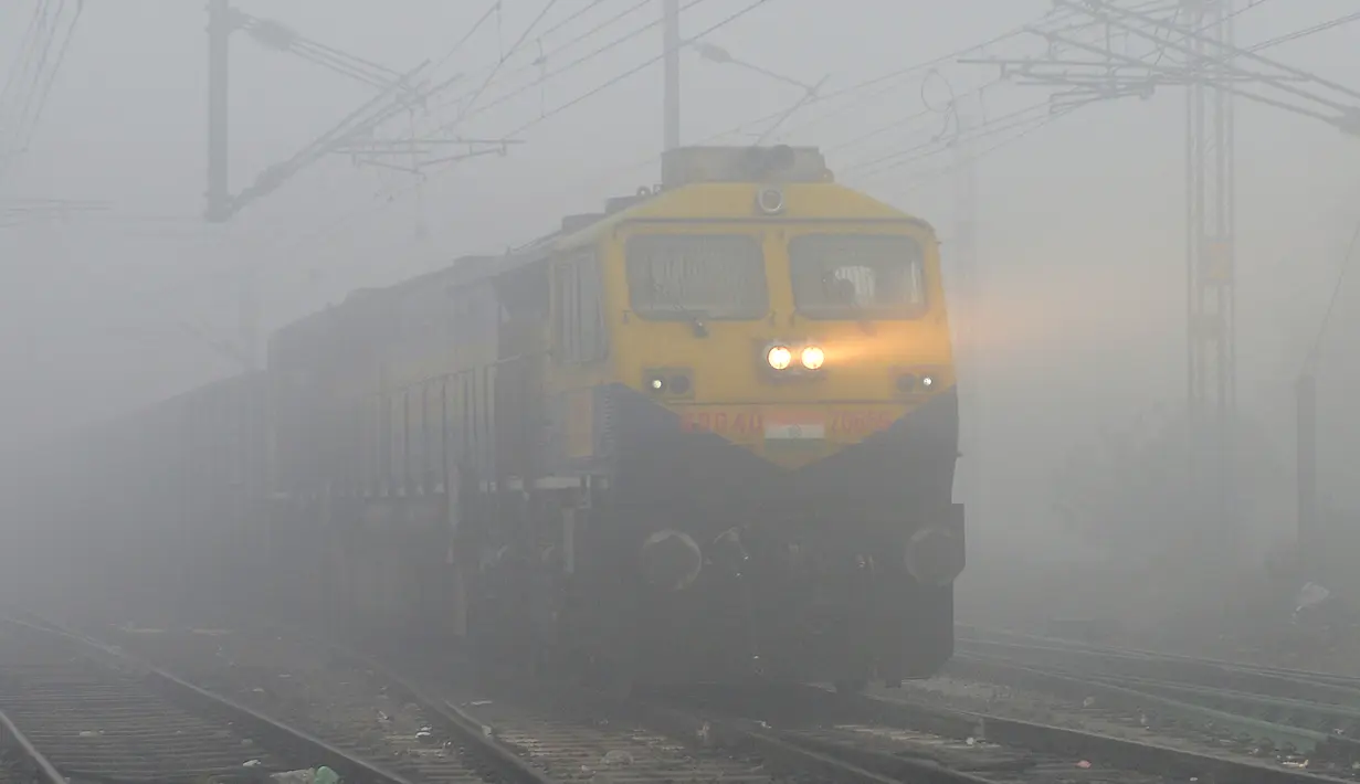 Sebuah kereta melaju dalam kabut tebal di Jalandhar (25/12). India ditetapkan darurat polusi udara. Kualitas udara yang semakin buruk dan kabut beracun menyelimuti seluruh kota. (AFP Photo/Shammi Mehra)