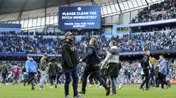 Suporter Manchester City berlari memasuki lapangan usai laga Manchester City melawan Swansea City pada lanjutan Premier League di Etihad Stadium, Manchester, (22/4/2018). Manchester City menang 5-0. (AP/Rui Vieira)