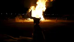 Penari beratraksi di depan bakaran api saat jelang perayaan "Jeongwol Daeboreum" di Seoul, Korea Selatan, Minggu (21/2). Tradisi perayaan "Jeongwol Daeboreum" ini merupakan bagian dari peringatan hari besar dalam penanggalan Imlek. (REUTERS/Kim Hong-Ji)