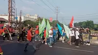 Massa pemuda di simpang Kampus UNISMA 45, Jalan Raya Cut Mutia, Bekasi Timur, Kota Bekasi, menolak aksi buruh yang hendak berdemo ke Jakarta. Foto: Liputan6.com/Bam Sinulingga