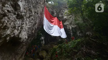 Jaringan Masyarakat Peduli Karst Klapanunggal membentangkan bendera merah putih dalam rangka peringatan HUT ke-75 RI di Tebing Kutalingkung, Klapa Nunggal, Jawa Barat, Senin (17/8/2020). Sebanyak 80 orang mengikuti pengibaran bendera berukuran 15 meter x 10 meter tersebut. (merdeka.com/Imam Buhori)