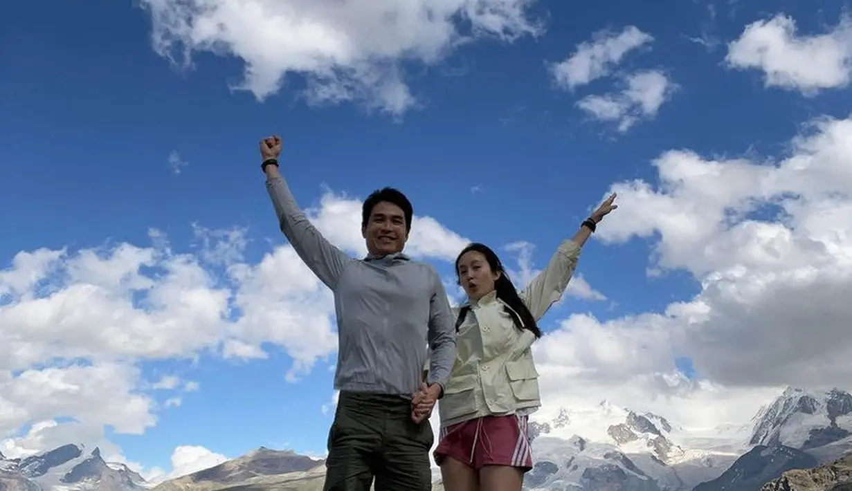 Saat naik gunung, keduanya tampil sporty. Nong Poy mengenakan jaket putih dipadukan short pants pink. Sang suami dengan jaket training dan short pants. [@poydtreechada]